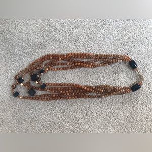 Multi strand necklace of amber colored beads, with navy blue and gold accents